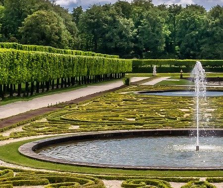 Jardín formal con áreas verdes y fuente